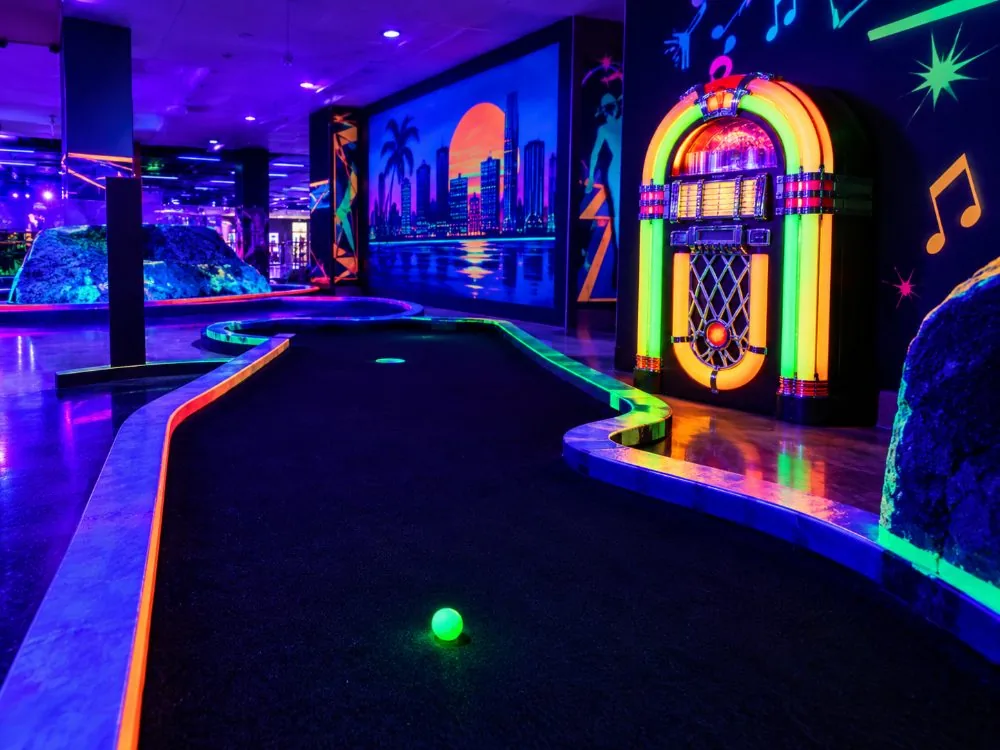 A glowing hole on the blacklight mini-golf course