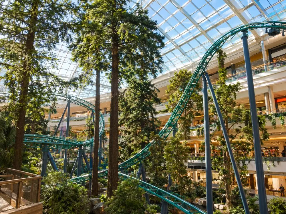 Roller-coaster track and trees under the glass roof of the theme park at Mall of America